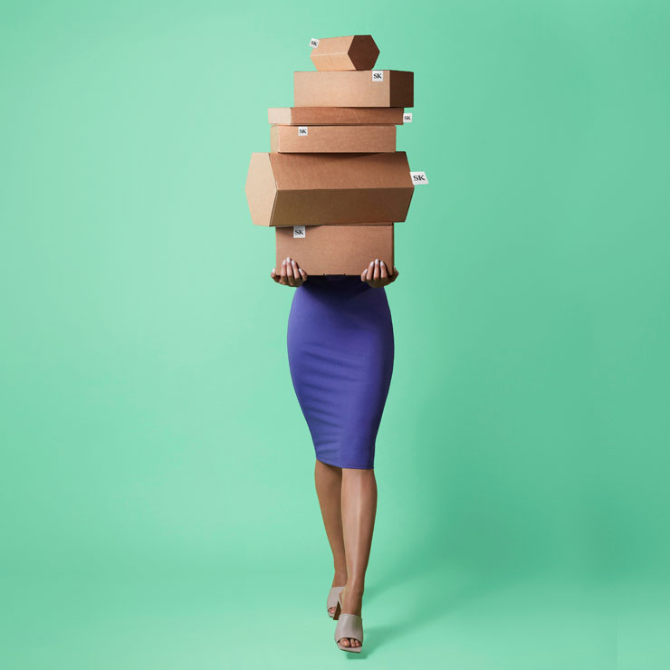 Image d'une femme avec plusieurs emballages en carton destinés à l'expédition de produits du secteur de la mode