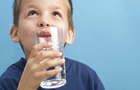 Un enfant buvant un verre d'eau
